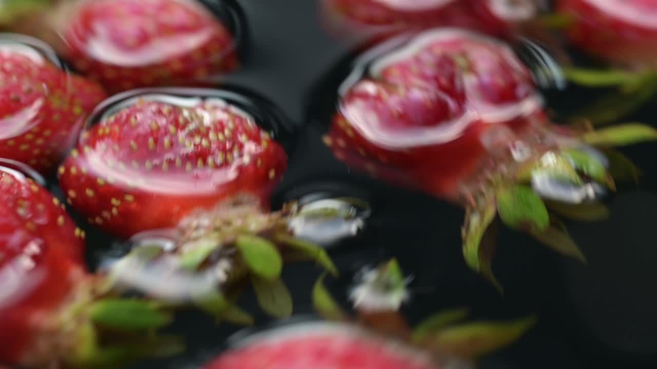 Watch nature's bounty at its finest with this close-up footage of organic strawberries being rinsed in well water