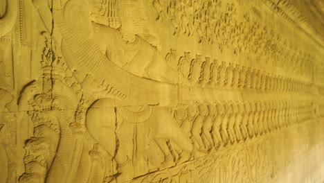 escultura tallada en bajorrelieve a lo largo de la pared del templo del lado este de angkor wat. representa a personas tirando de una serpiente con la esperanza de vida eterna, siem reap, camboya