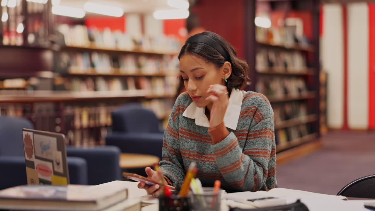 Woman studying in library with laptop and books