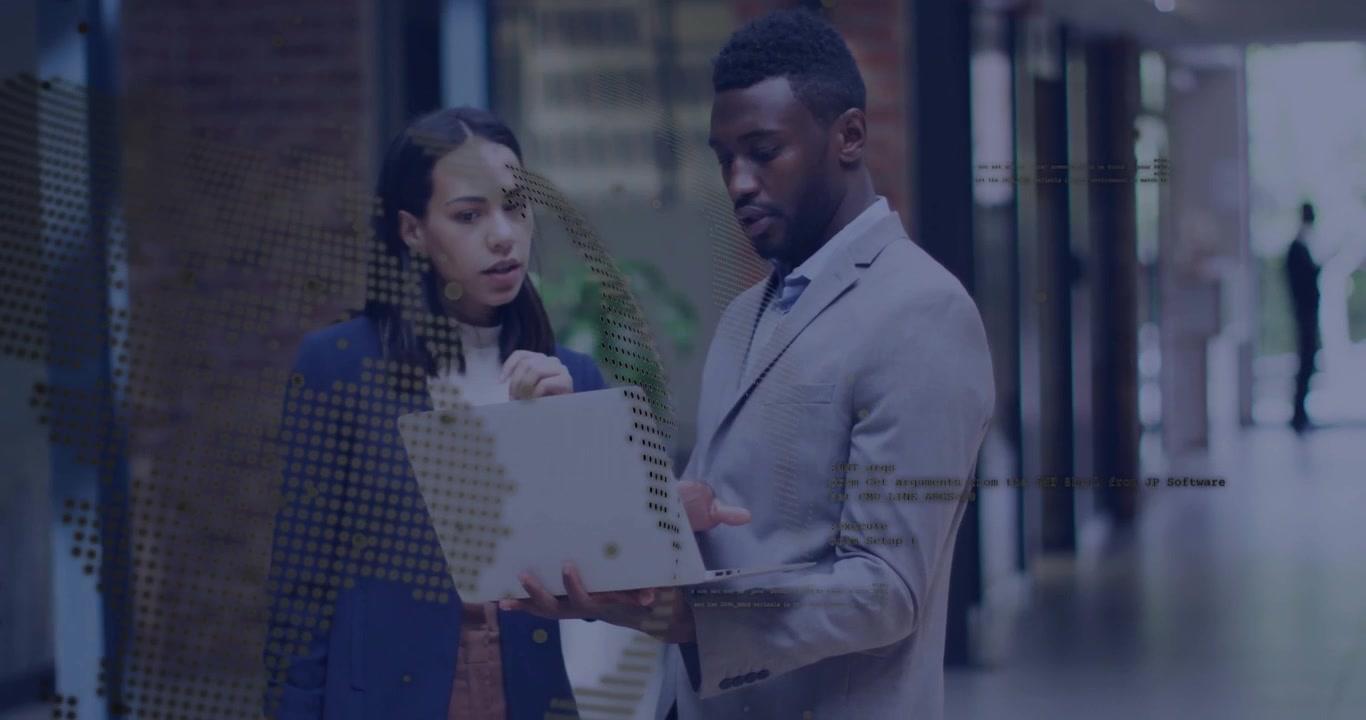 Business Professionals Collaborating on a Laptop in an Office Corridor