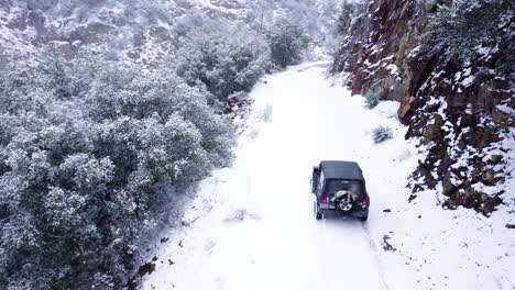 Jeep-driving-off-road-on-a-cliffside-in-a-snow-storm