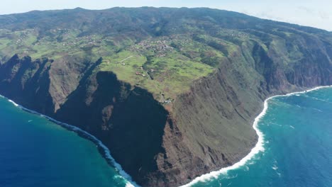 Incredible-steep-cliffs-of-Madeira-with-Ponta-do-Pargo-lighthouse,-aerial