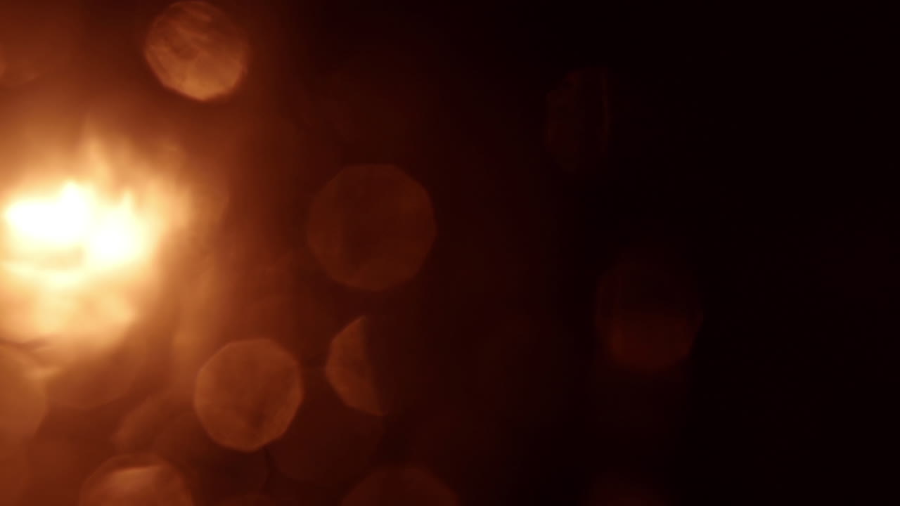 Sobreposição de Luz Bokeh Laranja em Movimento em Fundo Preto