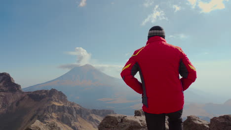 Rückansicht-Des-Manntrekkers,-Der-Steht-Und-Den-Dampfenden-Aktiven-Vulkan-Popocatepetl-Betrachtet