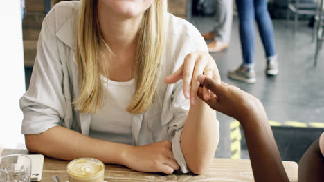 Beautiful-woman-showing-engadgement-ring-to-friends-in-cafe-plan-wedding