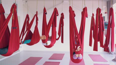 sleepy women group with bare feet relaxes in hammocks