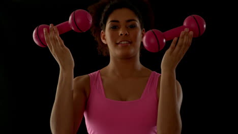 fit woman in pink exercising with dumbbells