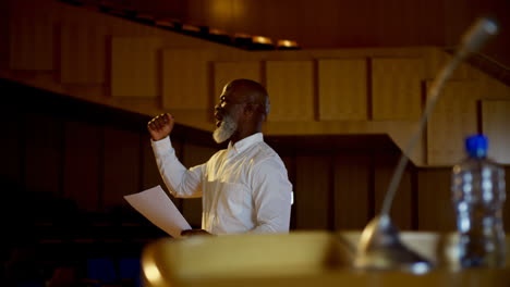 Senior-African-American-businessman-practicing-speech-in-empty-auditorium-4k