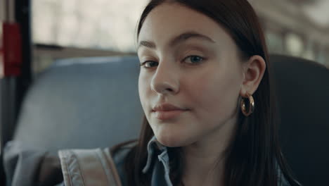 Closeup-brunette-girl-looking-in-camera-sitting-in-empty-school-bus-alone.