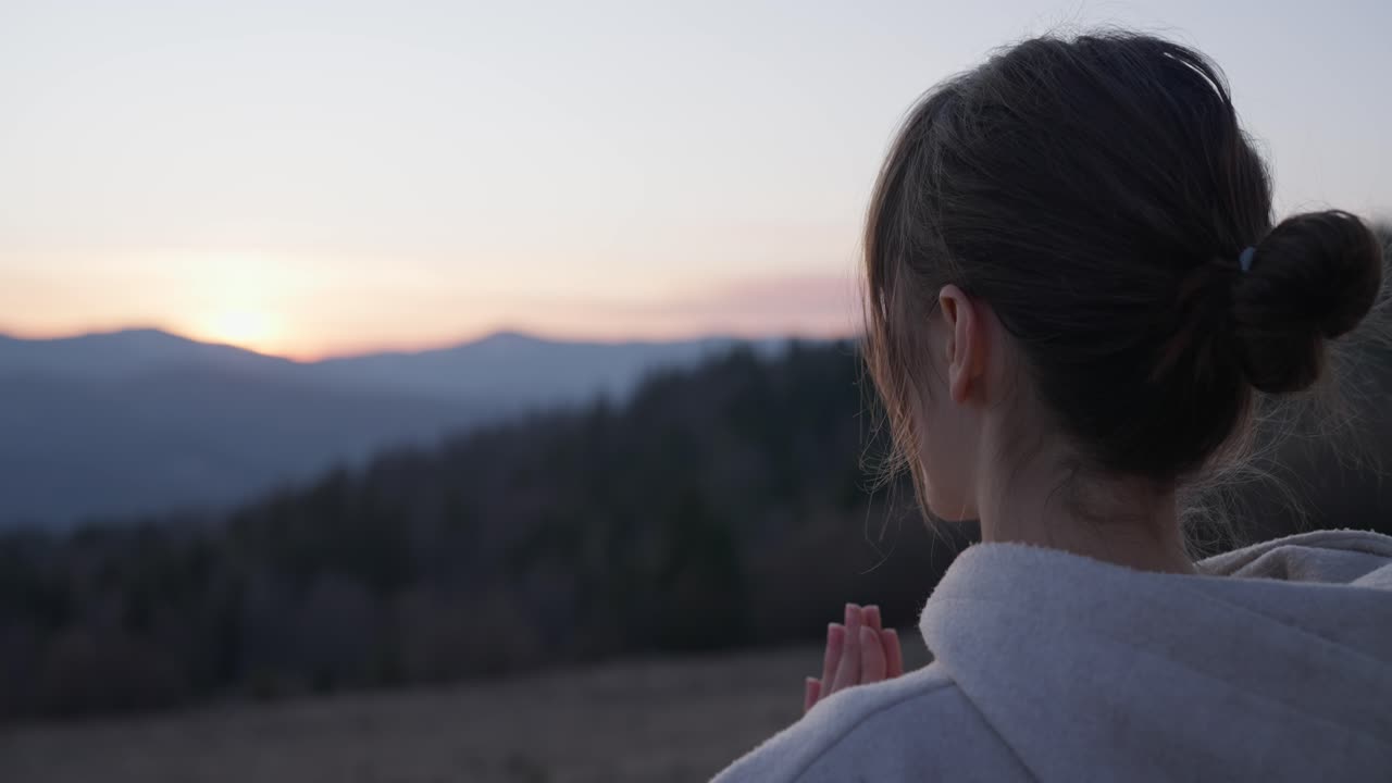 해가 지면 산에서 명상 하는 여자