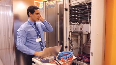 technician talking on mobile phone in server room