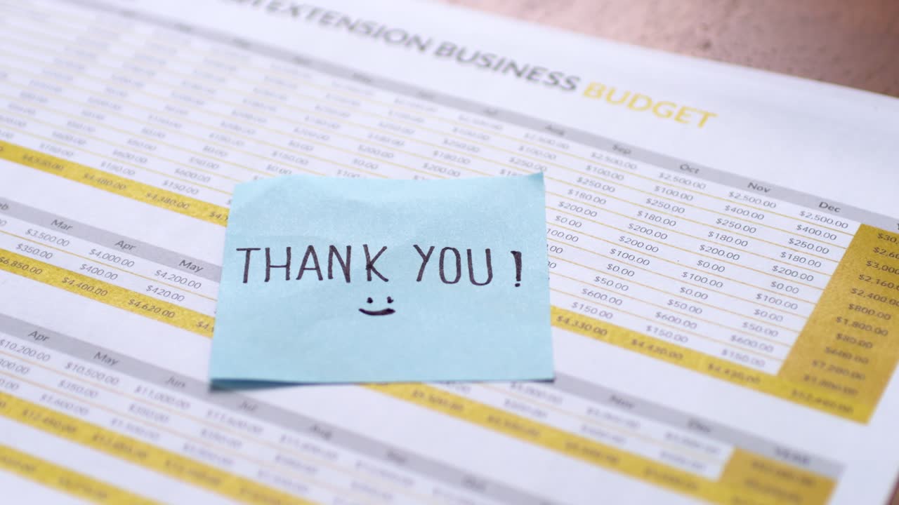 A business budget document features a thank you note highlighting gratitude in a professional office environment