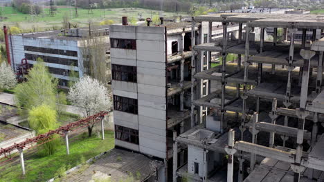 damaged industry. abandoned place with old unfinished buildings of a factory. old industrial plant in springtime. drone view.
