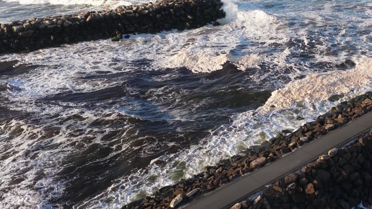 Dynamic ocean waves crash against a rocky breakwater at Brunswick Heads, NSW, captured in soft, natural lighting