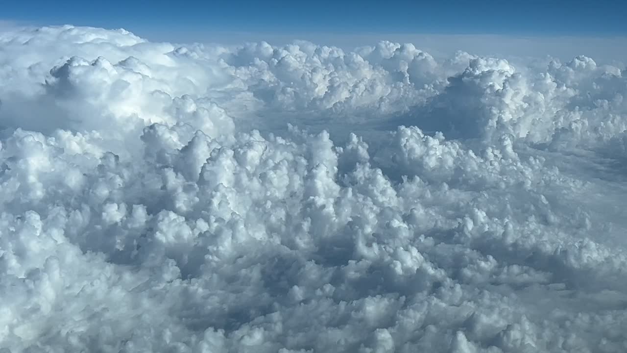 POV che vola sopra le nuvole temporalesche in un cielo blu.