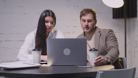 man and woman having a business meeting sitting at desk in boardroom