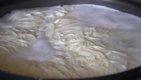 closeup boiling korean rice noodle guksu in a big pot