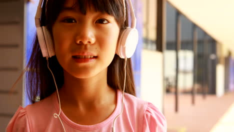 portrait of schoolgirl listening music on headphones 4k