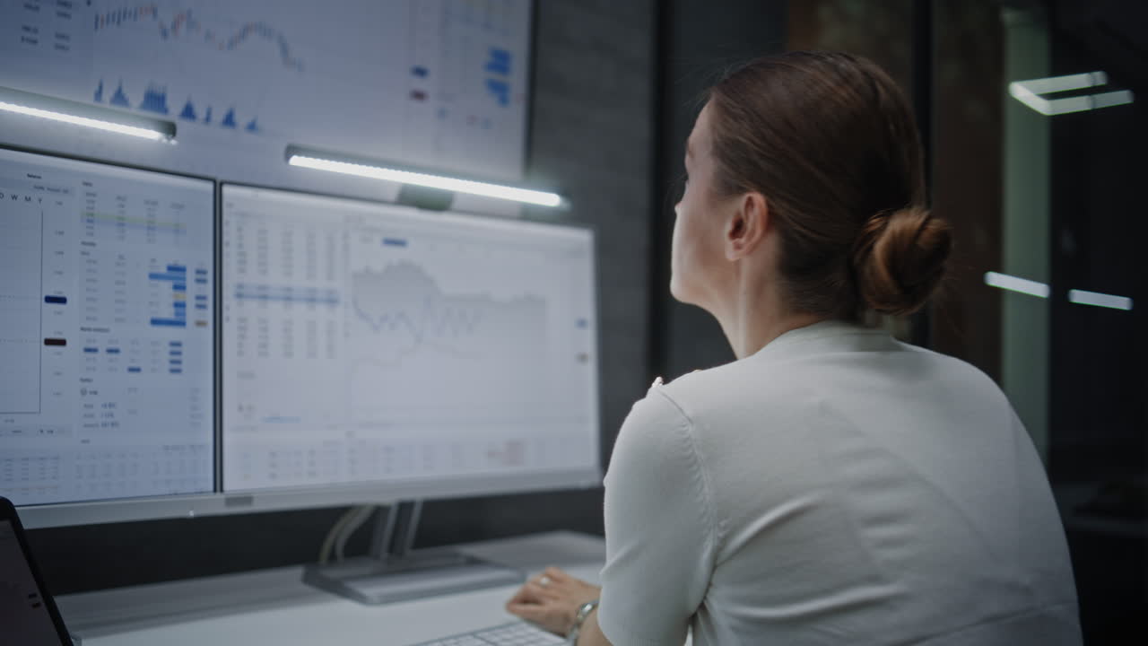 Female Stock Exchange Broker Talking on Phone, Monitoring Real-Time Stocks, Exchange Market Charts on Computer with Multi-Monitor Setup and Digital Tablet. Investment Agent Working in Office at Night.