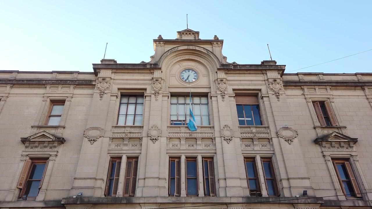 Facciata del Palazzo della Stazione Ferroviaria di Once con orologio e bandiera nazionale a Buenos Aires, Argentina