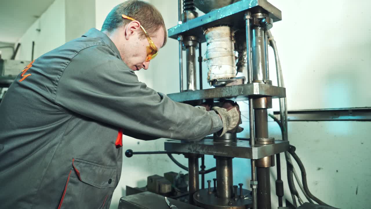 Hydraulic press heavy machine. Worker operating with hydraulic press at factory