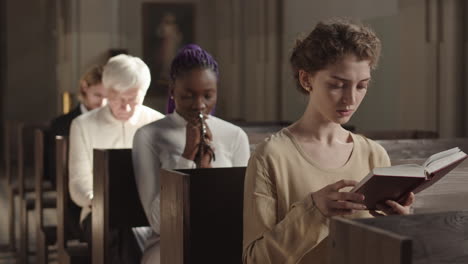 several multiethnic parishioners praying heartily in church