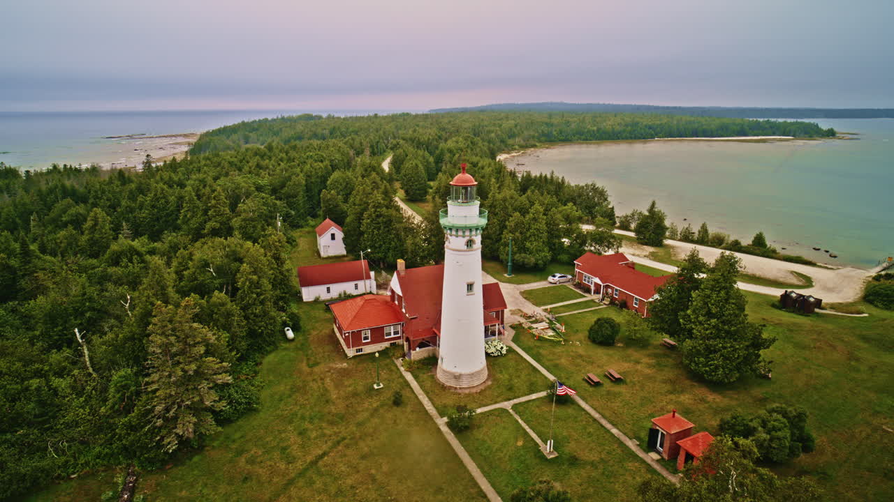 Drone shot panning around lighthouse on the shore of lake Michigan