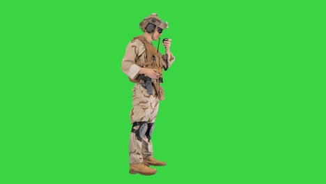 soldado de pie y hablando en la radio en una pantalla verde, clave de croma