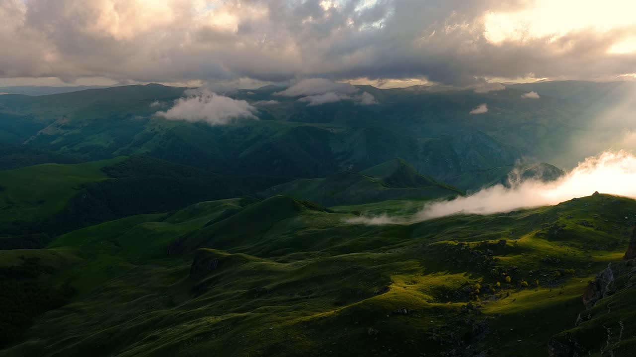 nubes bajas sobre una meseta montañosa en los rayos del atardecer. atardecer en la meseta de bermamyt norte del cáucaso, karachay-cherkessia, rusia.