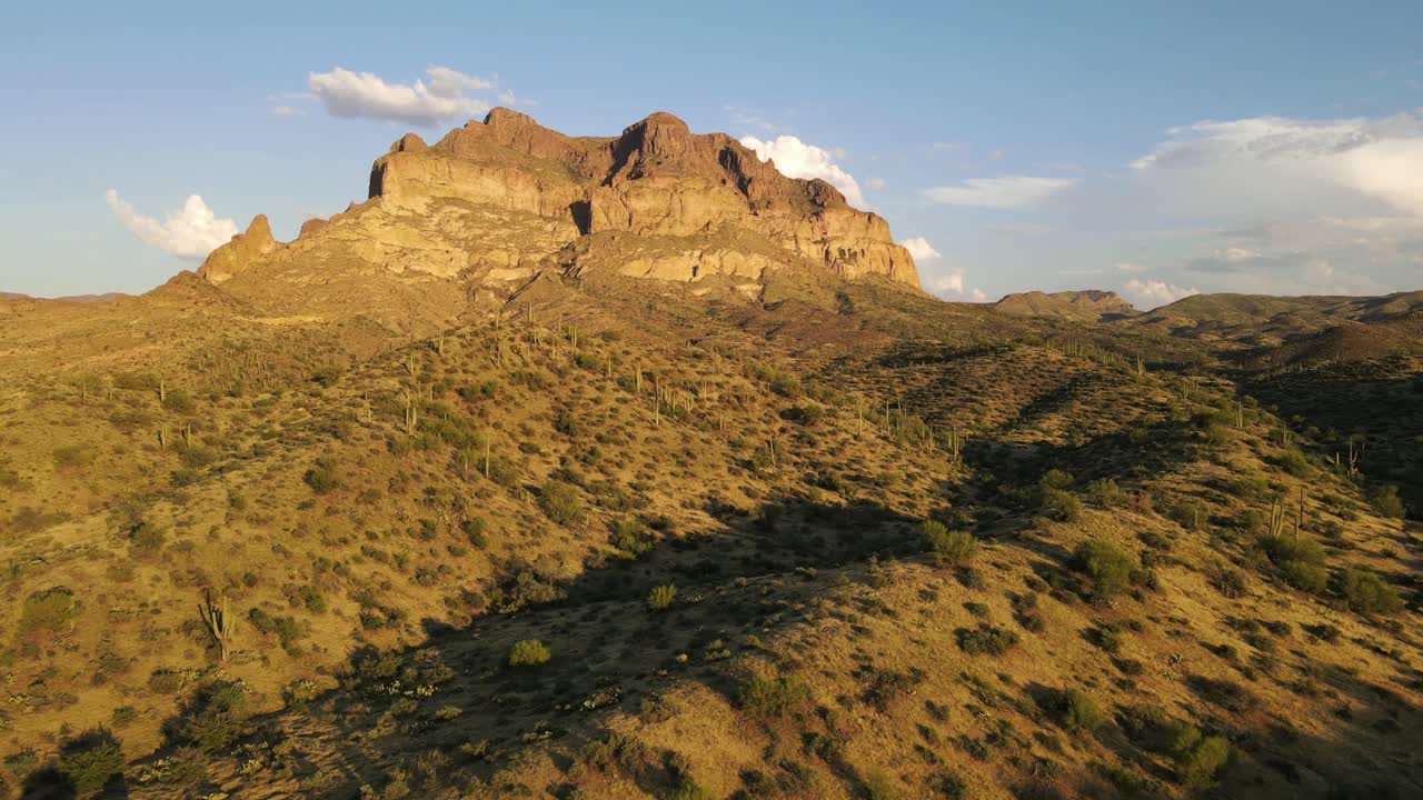 toma aérea, drone volando sobre el desierto a la hora dorada con montañas en el fondo, cactus y pincel en primer plano cerca de superior, arizona