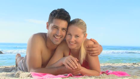 Cute-couple-lying-on-a-beach