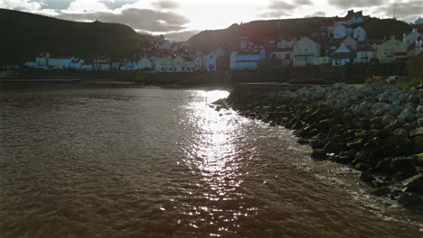 low pullback establishing drone shot of staithes coastal village uk