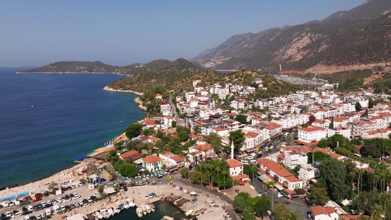Aerial dolly of Kas, Antalya, Turkey, showing the town’s coastline with boats, clear blue waters, and Mediterranean scenic views