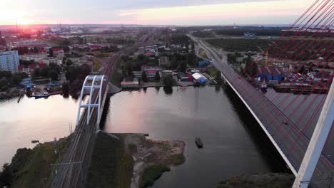aerial dolly shot of cable-stayed bridge and train bridge on motława river in gdansk, poland