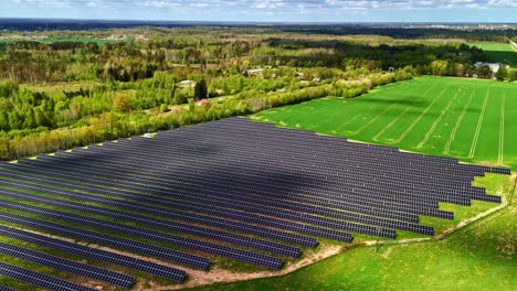 multiple solar panels lying in open space fields during a sunny day. aerial drone shot
