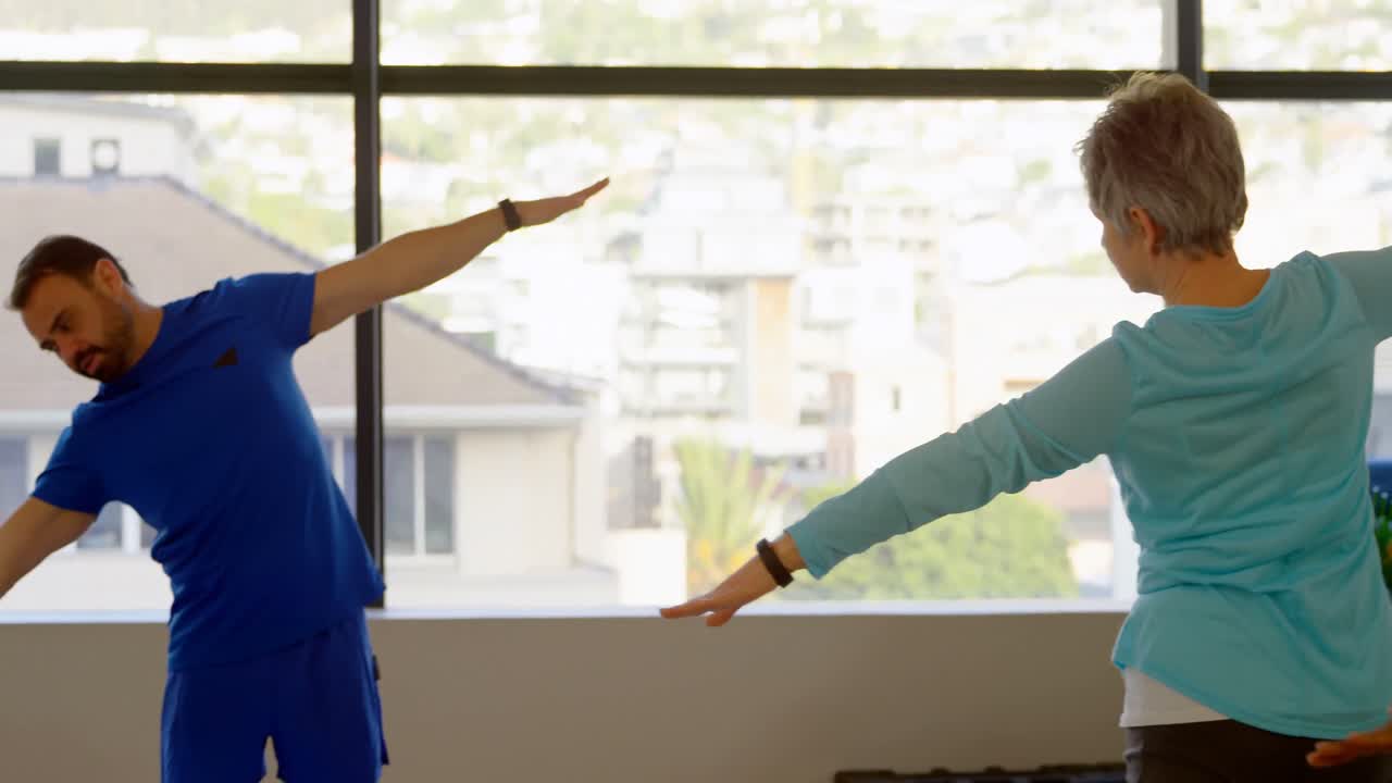 요가 4k를 수행하는 고령 여성들을 돕는 트레이너