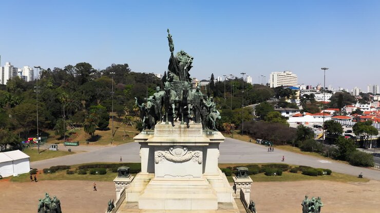 Camera flying down and away from the Independence Monument in the Independence Park with the Ipiranga Museum in the background of the scene