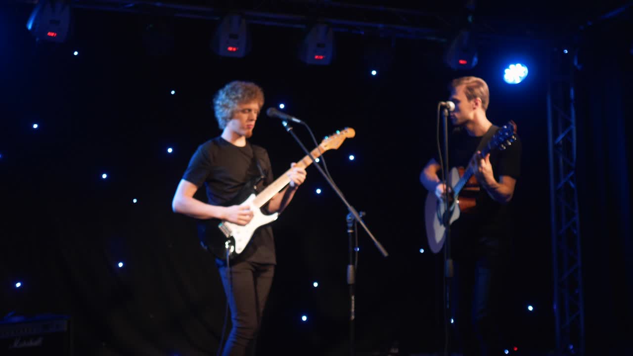 콘서트 록 밴드, 두 개의 전기 기타와 함께 무대에서 공연하는 가수, 뮤직비디오 크, 헤비 메탈 또는 록 그룹, 느린 동작 악기 연주 두 사람의 밴드