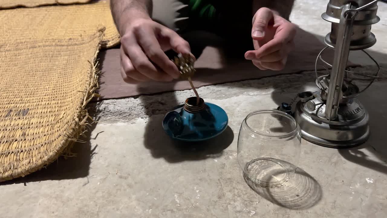 remojar la lámpara de mecha en el aceite para encender linterna con fósforos concepto de iluminación de manera tradicional en el área rural como vela lámpara de arcilla antigua con vidrio delgado brillo por la noche vieja luz en oriente medio