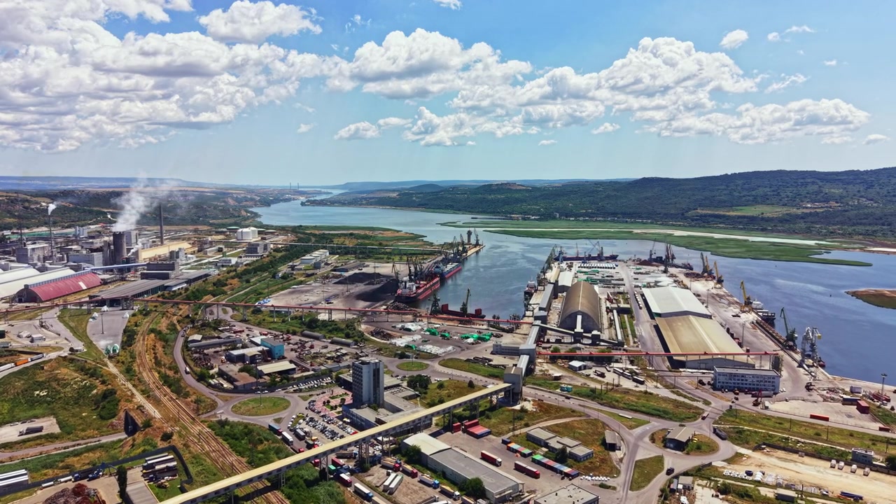 Vista di un'area industriale lungo il fiume che mostra attività di spedizione e strutture di stoccaggio situate in un porto trafficato di giorno