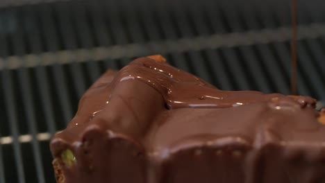 un pedazo de pastel de queso con chocolate se vierte con salsa de chocolate