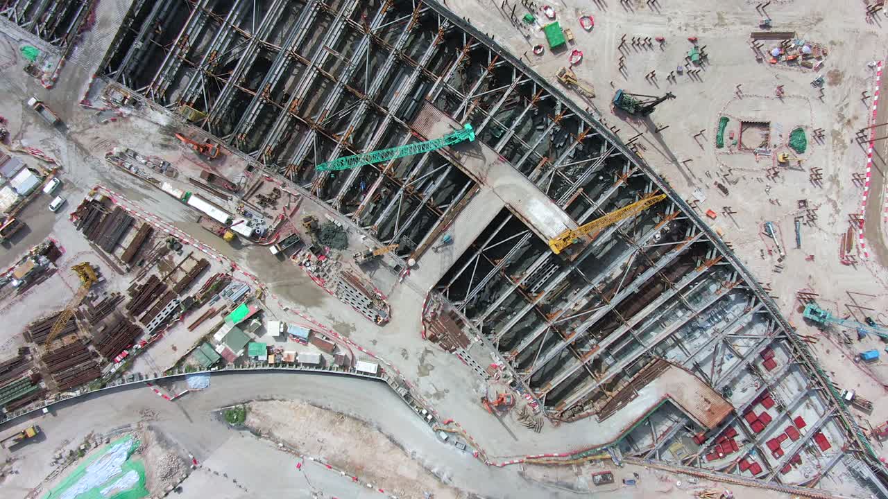 Converting an old runway strip into a Housing and business district at Kai Tak downtown Hong Kong, with vast infrastructure development land and an underwater tunnel laying operation, Aerial view.