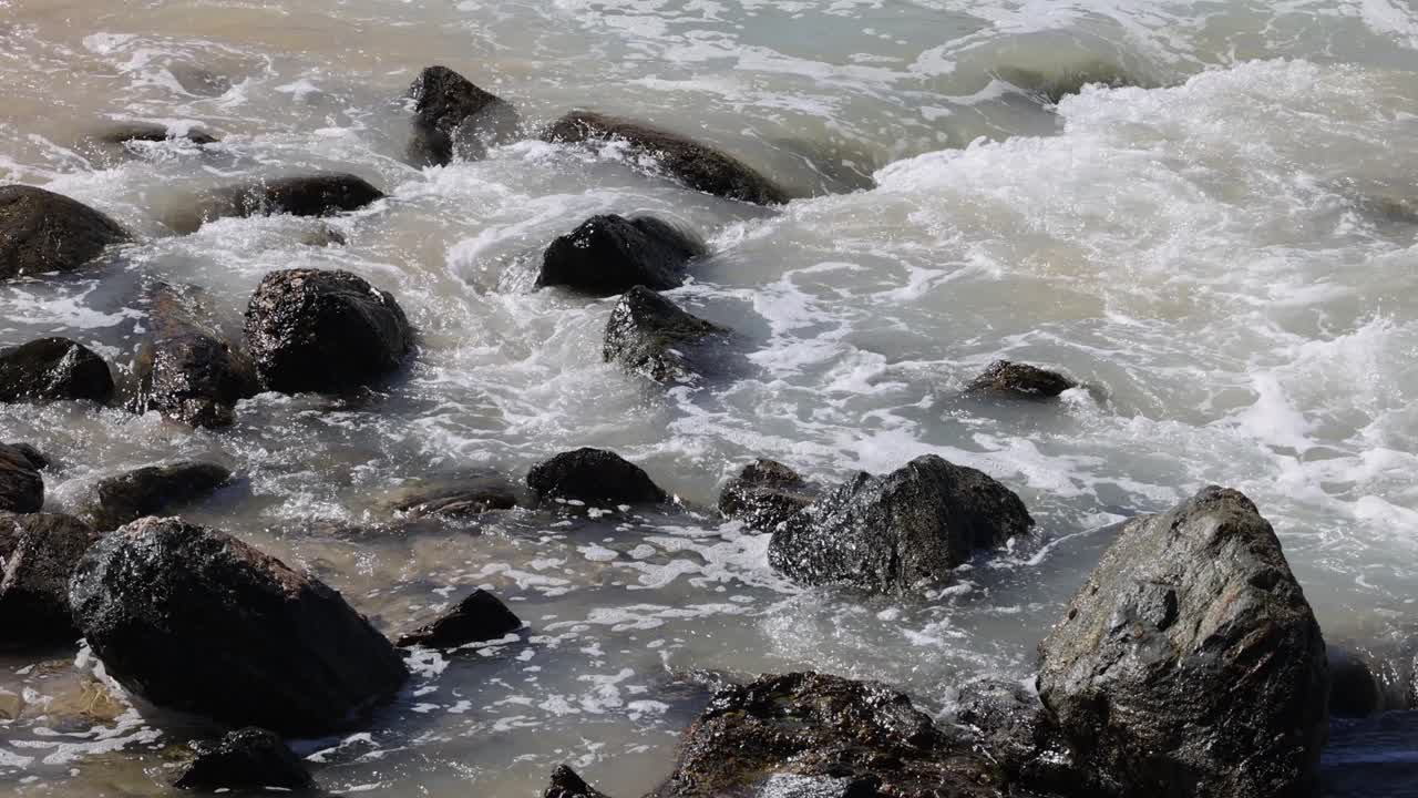 물은 물에 잠긴 바위 위에서 역동적으로 흐릅니다.