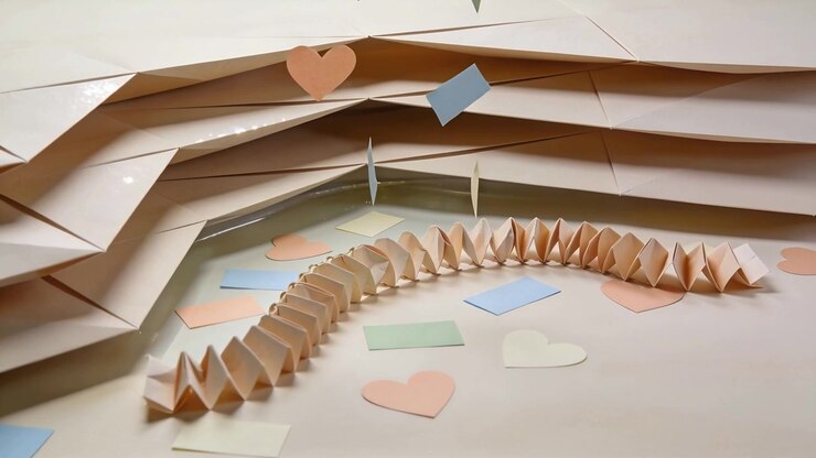 Accordion paper chain curving on table while pastel hearts drifting near beige sheet, AI-generated