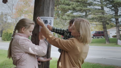 a woman with children pastes ads about a missing puppy