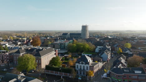 scaffolding around the clock tower of the basilica of our lady in tongeren, aerial forward