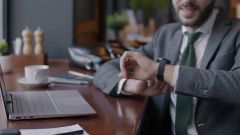 businessman paying with smartwatch in cafe