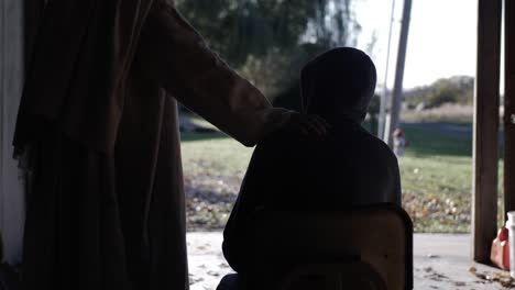 jesus wearing a white robe offers his hand to a sad, lonely looking teenage boy