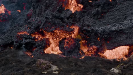 primer plano de lava derretida que fluye lentamente desde el volcán grindavik en el cráter sundhnúkur, islandia