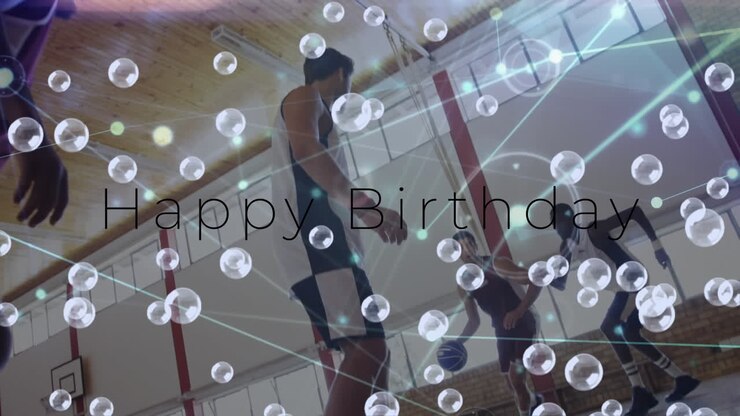Animation of happy birthday text and bubbles over diverse group of basketball players at gym